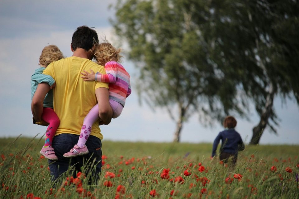 young dad with kids in field